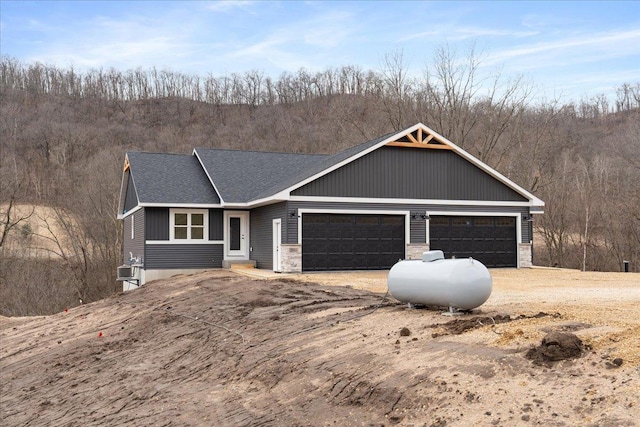 S1546 Shawnee Dr Unit A, Alma, WI 54610 - view of front of home with driveway, a garage, a shingled roof, and a view of trees