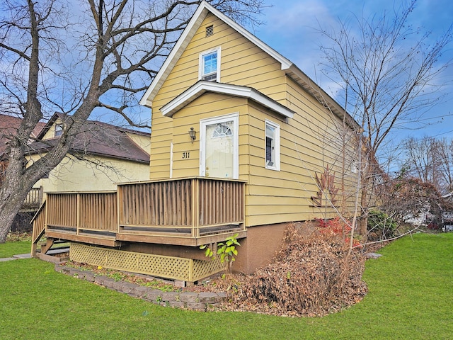 back of house featuring a wooden deck and a yard