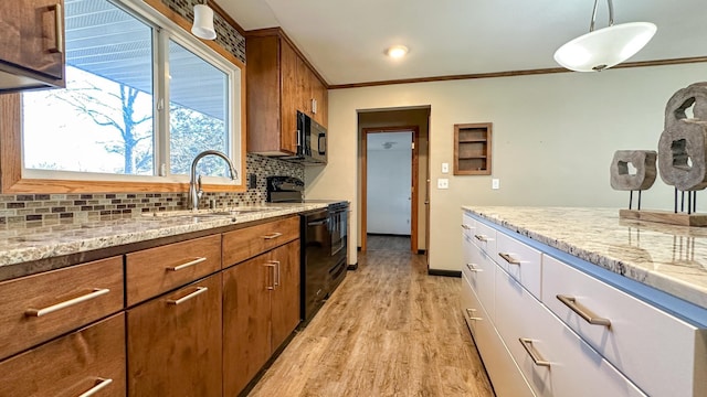 kitchen featuring pendant lighting, black appliances, sink, light hardwood / wood-style flooring, and decorative backsplash