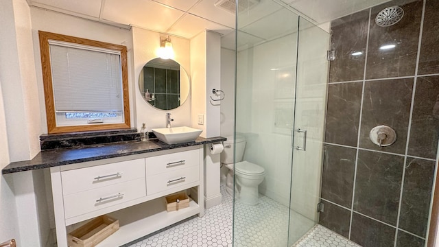 bathroom featuring tile patterned flooring, vanity, toilet, and an enclosed shower