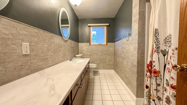 bathroom with vanity, tile walls, tile patterned flooring, toilet, and curtained shower