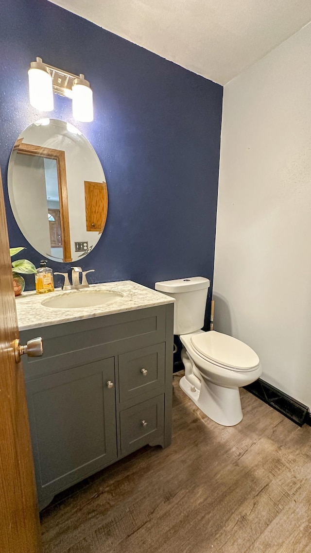 bathroom featuring hardwood / wood-style floors, vanity, and toilet