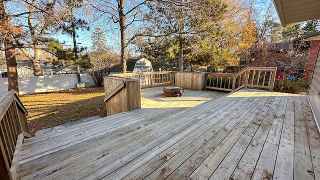 deck featuring a storage unit and an outdoor fire pit