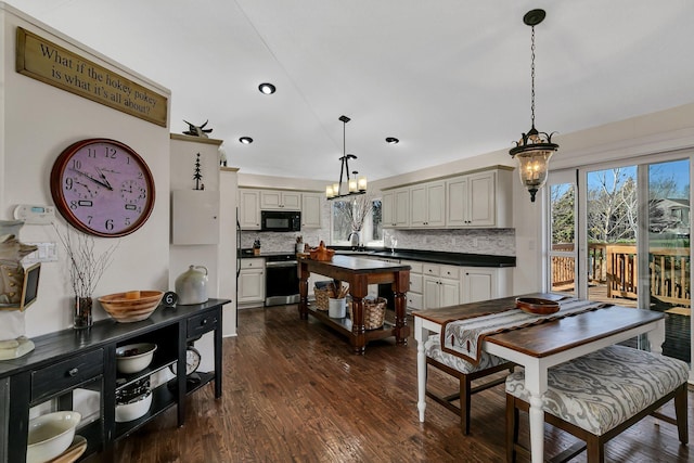 kitchen featuring decorative backsplash, hanging light fixtures, dark hardwood / wood-style floors, and cream cabinets