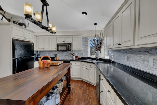 kitchen with sink, black appliances, decorative light fixtures, white cabinets, and dark hardwood / wood-style flooring