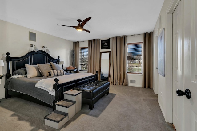 carpeted bedroom with multiple windows and ceiling fan