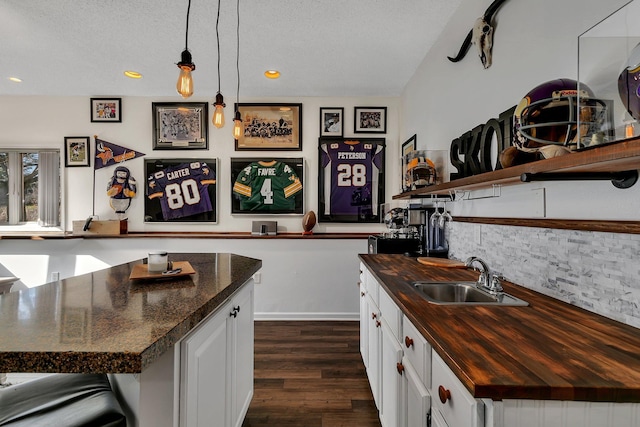 kitchen featuring hanging light fixtures, white cabinetry, sink, and a kitchen island