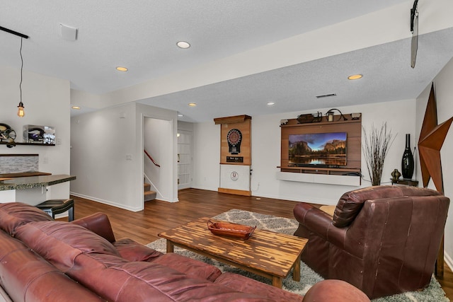 living room with dark wood-type flooring and a textured ceiling