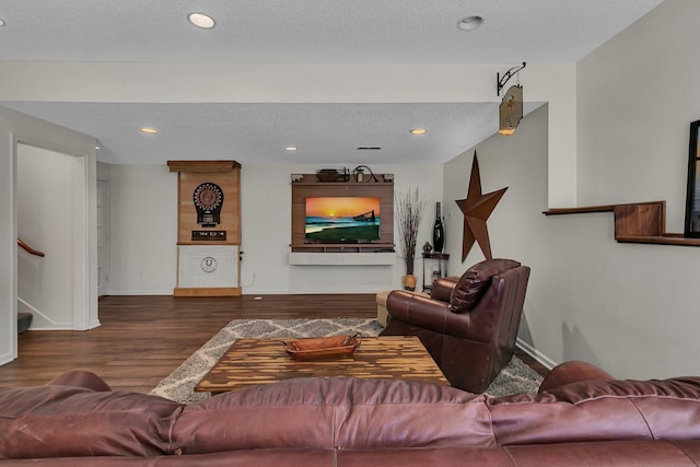 living room featuring dark wood-type flooring and a textured ceiling