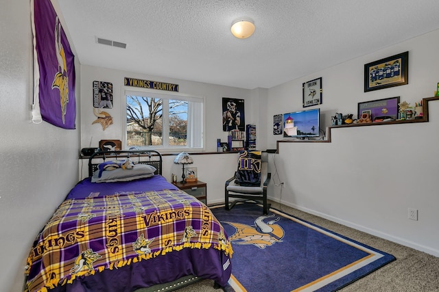 bedroom featuring a textured ceiling and carpet floors