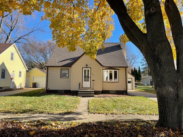 bungalow-style home with an outdoor structure, a front yard, and a garage