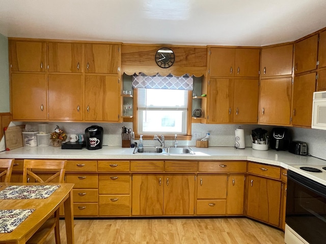 kitchen featuring white appliances, sink, decorative backsplash, and light hardwood / wood-style floors