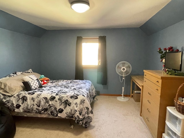 bedroom featuring light colored carpet and vaulted ceiling