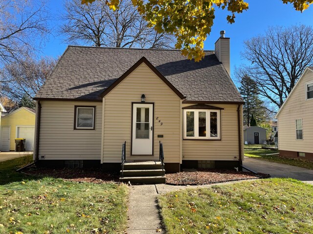 bungalow-style house featuring a front lawn