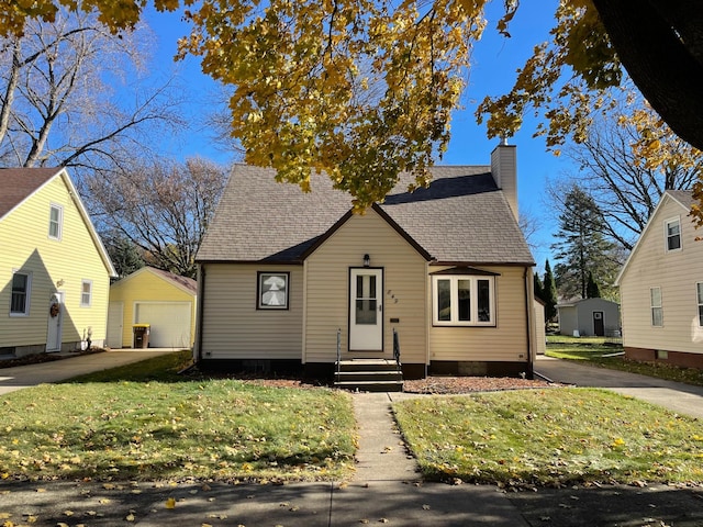 bungalow-style home with a garage, a front lawn, and an outdoor structure