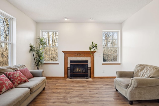 living room featuring a textured ceiling, a fireplace, and light hardwood / wood-style floors