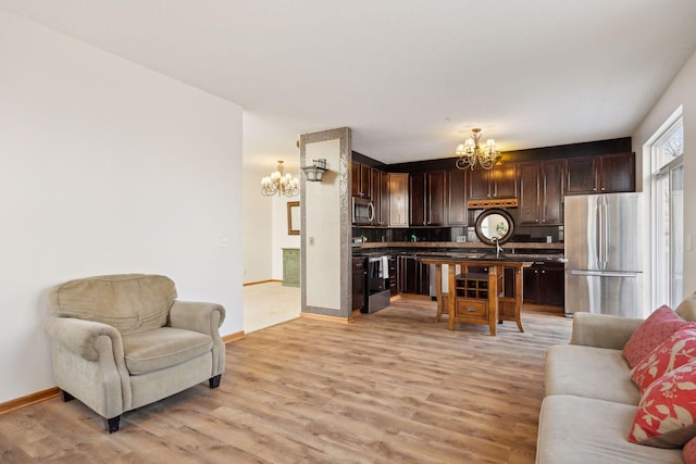 living room featuring a notable chandelier and light wood-type flooring