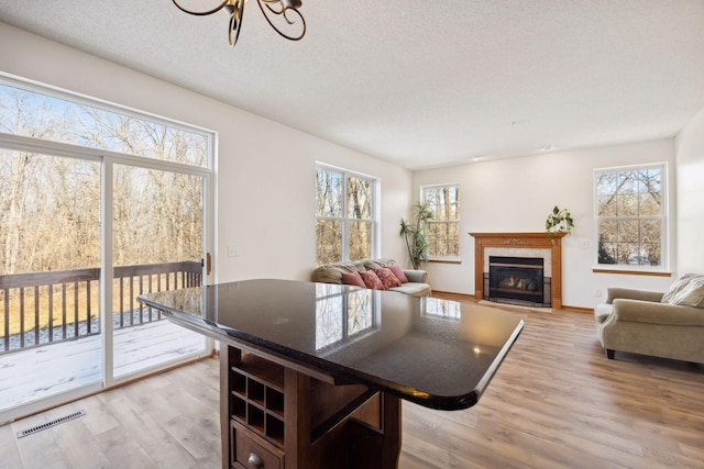 dining space featuring a tiled fireplace, hardwood / wood-style flooring, and a textured ceiling