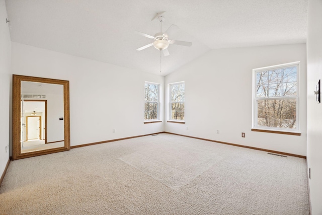 carpeted spare room with ceiling fan and vaulted ceiling