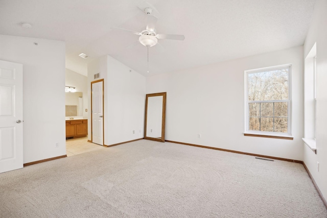 carpeted spare room featuring ceiling fan and vaulted ceiling