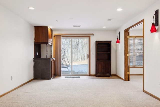 unfurnished living room featuring light colored carpet