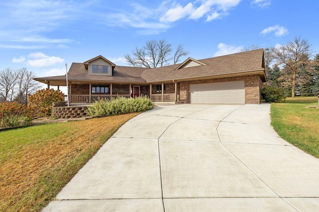 view of front of property featuring a front lawn, a porch, and a garage