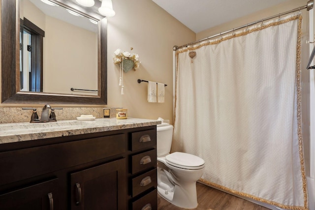 bathroom featuring a shower with curtain, vanity, hardwood / wood-style flooring, and toilet