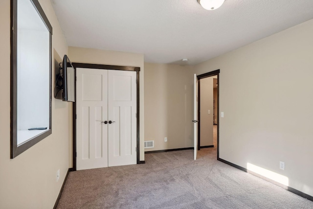 unfurnished bedroom featuring light carpet and a closet