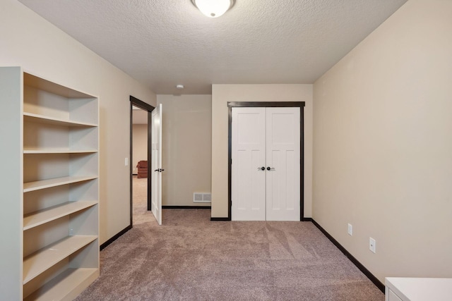 unfurnished bedroom with carpet floors and a textured ceiling