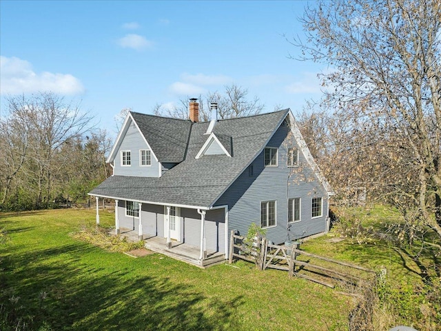 back of house with a porch and a yard