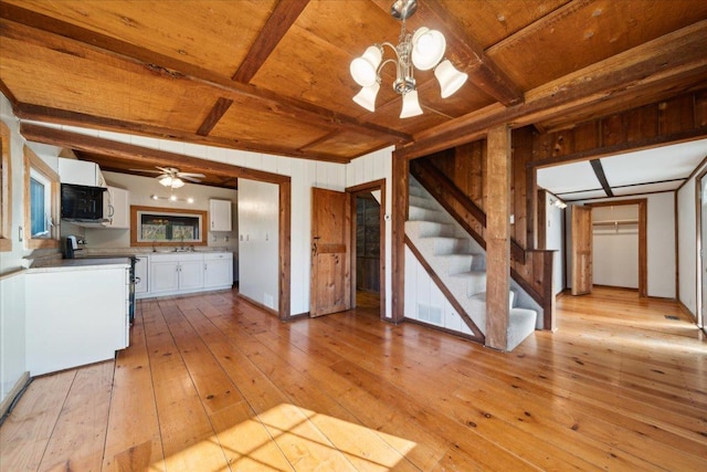 kitchen with stove, white cabinetry, wood ceiling, and beamed ceiling