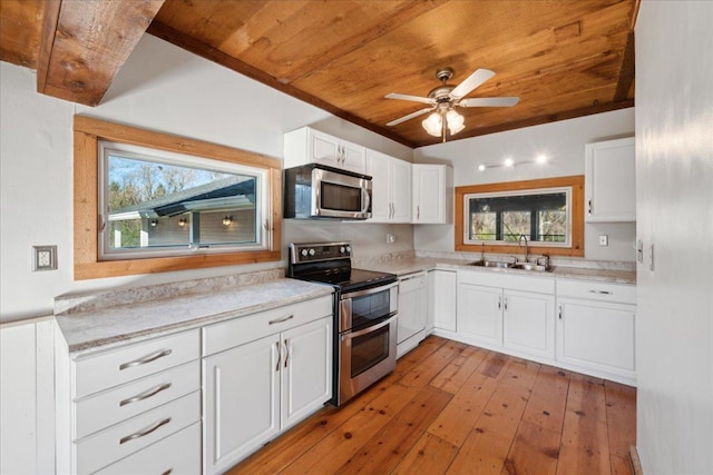 kitchen with white cabinets, appliances with stainless steel finishes, sink, wooden ceiling, and light hardwood / wood-style flooring