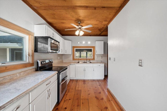 kitchen with appliances with stainless steel finishes, wood ceiling, and white cabinets