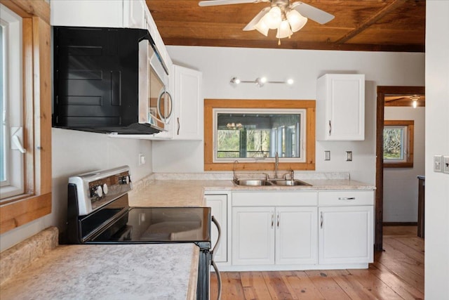 kitchen with white cabinets, appliances with stainless steel finishes, wood ceiling, sink, and light hardwood / wood-style flooring