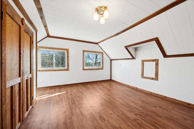 bonus room with vaulted ceiling and wood-type flooring