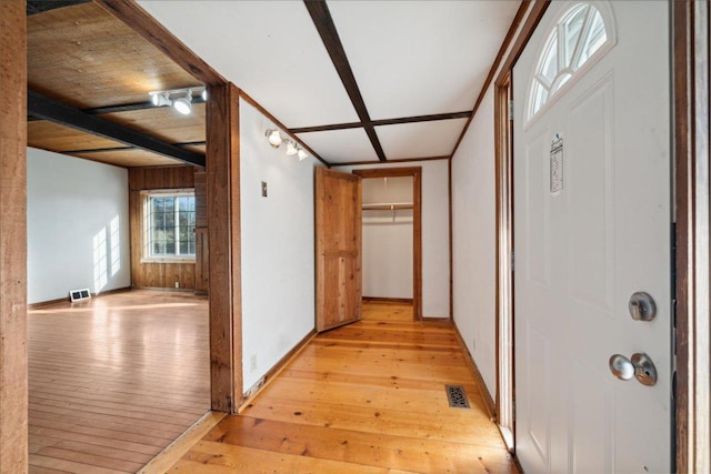 corridor featuring light hardwood / wood-style floors and beam ceiling