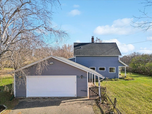 view of property exterior with a garage, a yard, and an outbuilding