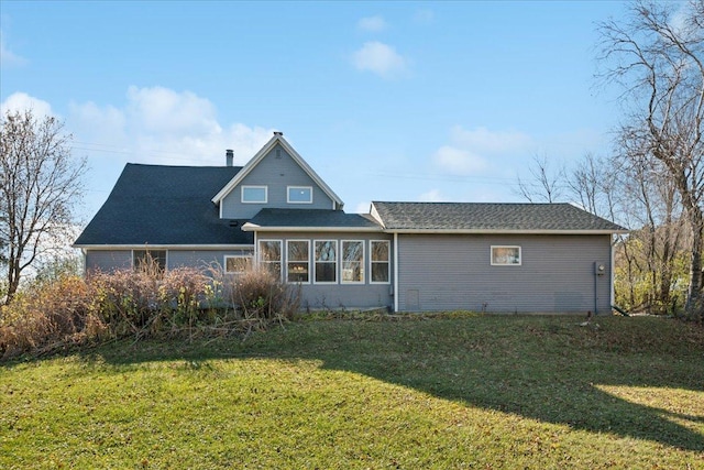 back of property featuring a sunroom and a yard