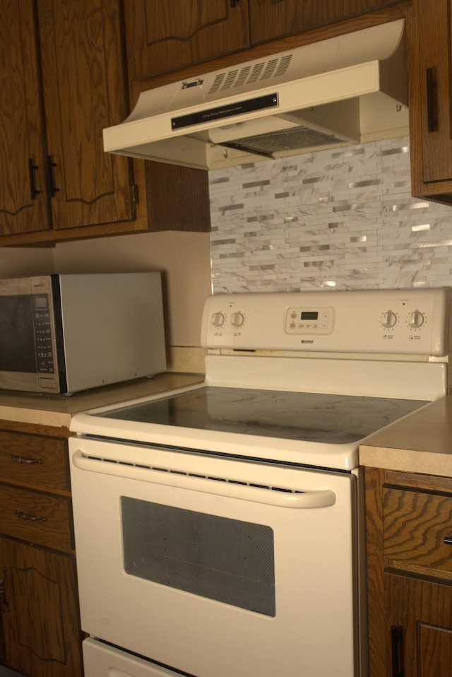 kitchen featuring decorative backsplash and electric range