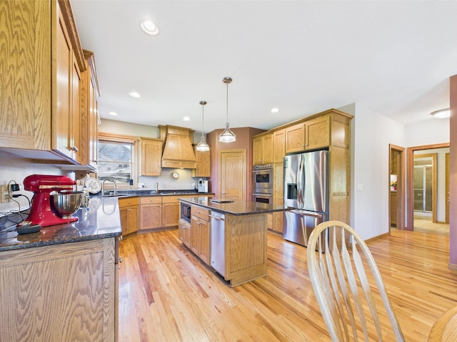 24850 Edenvale Trl, Elko New Market, MN 55020 - kitchen featuring appliances with stainless steel finishes, premium range hood, light wood-style floors, a kitchen island, and dark stone countertops