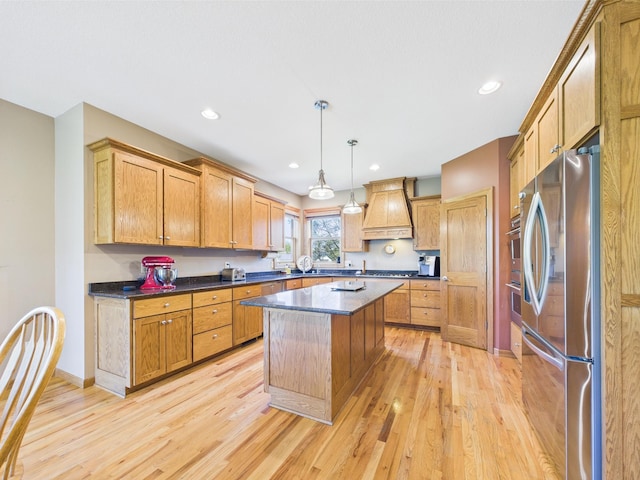 24850 Edenvale Trl, Elko New Market, MN 55020 - kitchen with freestanding refrigerator, custom exhaust hood, a kitchen island, light wood-style floors, and dark countertops