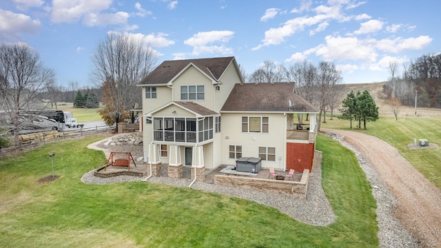24850 Edenvale Trl, Elko New Market, MN 55020 - rear view of house featuring a sunroom, a patio, a hot tub, dirt driveway, and roof with shingles