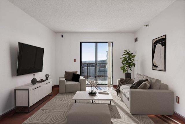 living room with dark hardwood / wood-style flooring and a textured ceiling