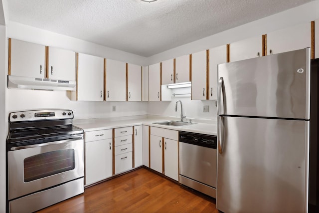 kitchen with white cabinets, stainless steel appliances, sink, and dark hardwood / wood-style floors