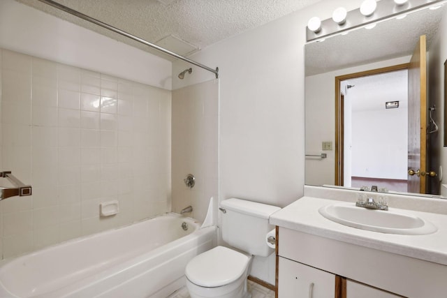 full bathroom with tiled shower / bath, a textured ceiling, toilet, and vanity