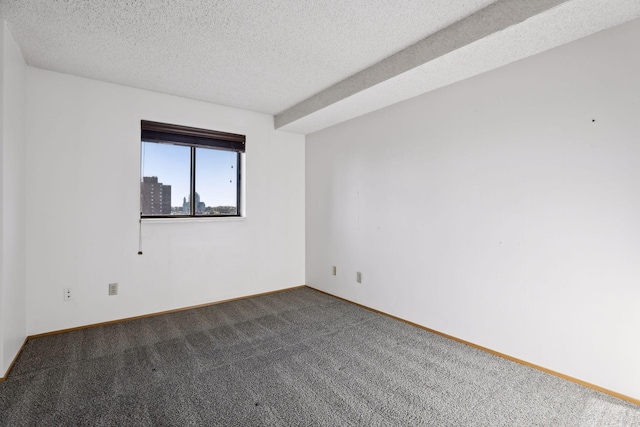 spare room featuring a textured ceiling and dark carpet