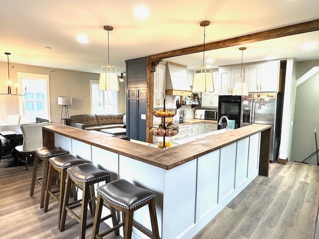 820 Labree Ave N, Thief River Falls, MN 56701 - kitchen with wood counters, white microwave, stainless steel fridge, light wood finished floors, and white cabinetry
