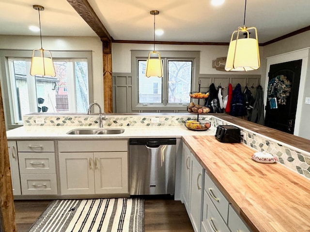 kitchen featuring sink, wooden counters, plenty of natural light, stainless steel dishwasher, and pendant lighting