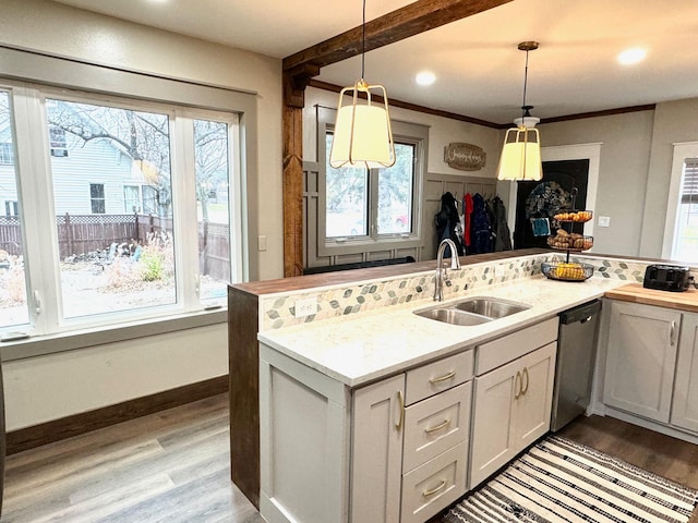 kitchen featuring white cabinetry, sink, pendant lighting, and dishwasher