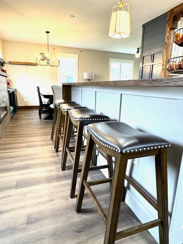 dining area with light hardwood / wood-style floors and an inviting chandelier